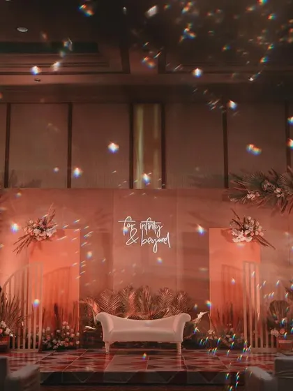 A dramatic, sparkling stage for an engagement party. The warm lighting, shimmering chandeliers, and bohemian backdrop of dried florals created a glamorous and unforgettable setting.