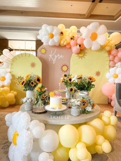 A sunny and cheerful first birthday party. The theme was brought to life with daisy and sun-shaped balloon arches, fresh sunflowers, and a custom backdrop, creating a joyful space for a little one's big day.