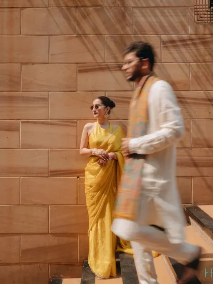 An artistic shot with the groom in motion blur walking past the bride, creating a dynamic and modern Haldi portrait.