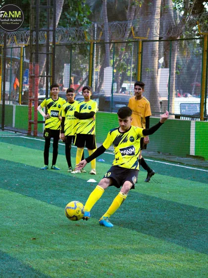 A player practices his shooting technique, aiming for the corner of the goal.