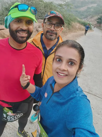 A selfie of three runners mid-race on the Aravali trail. The camaraderie on the course is just as important as the finish time.