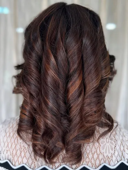 A full back view of the tightly curled brown hair, highlighting the consistency of the color and the definition of the curls.