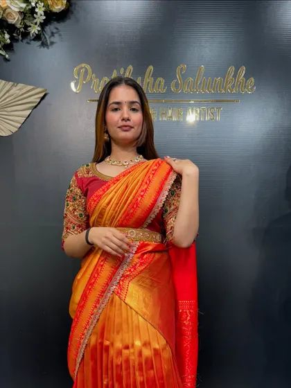 A beautiful half-saree look in shades of orange and red. This is a popular choice for young women at family functions and festivals in South India.