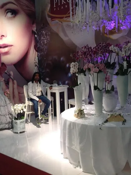 A beautiful, high-fashion orchid display at an international show. The combination of dramatic lighting, white fabrics, and elegant flowers creates a very luxurious feel.