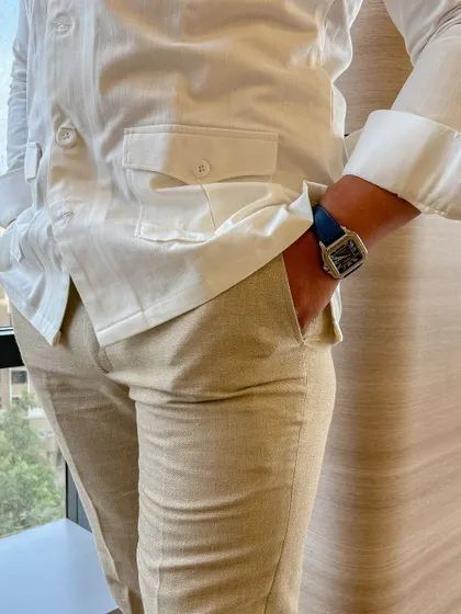A closer look at the safari shirt and linen trousers. The fit is relaxed for comfort, but the tailoring is precise, ensuring a smart silhouette.