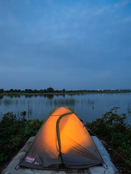 A single tent glows against the twilight sky over the lake. This image perfectly captures the peace and beauty of an overnight stay at our campsite.