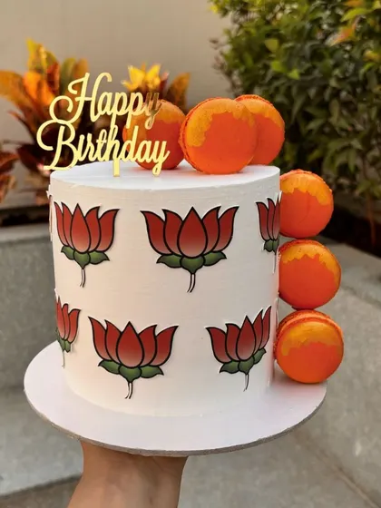 A custom cake for a BJP supporter, featuring the lotus symbol and orange macarons. I can create cakes for any political affiliation or event.