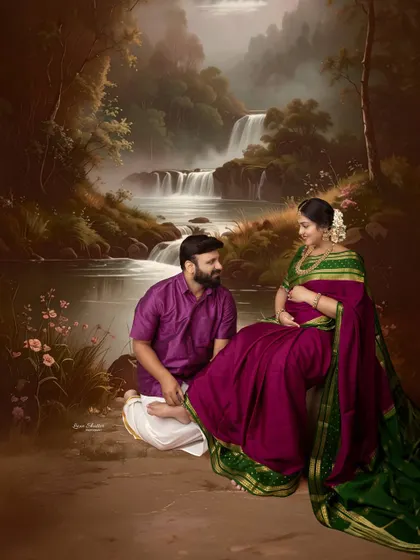 A breathtaking, painterly maternity portrait set against a majestic waterfall backdrop. The couple's traditional attire adds a layer of cultural elegance to this fine-art piece.