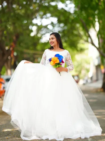 The classic white ball gown is perfect for a bridal-themed pre-wedding shoot. Holding a colorful bouquet adds a lovely pop of color.