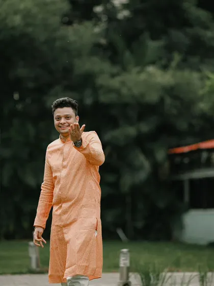 A candid and welcoming shot of the groom at his reception, his smile full of happiness and excitement.