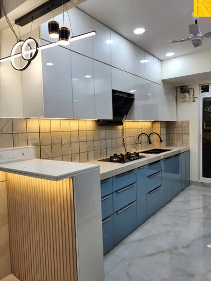 This shot shows the breakfast counter with modern pendant lighting, which adds an extra functional surface to the kitchen.