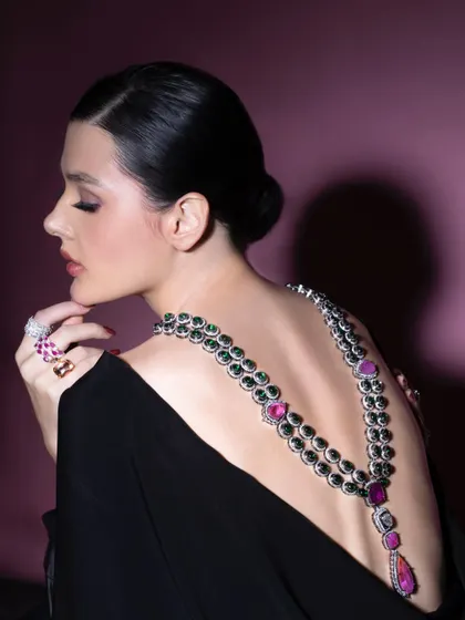A profile shot showcasing a stunning back-draping necklace. This unconventional way of wearing jewelry highlights the piece's versatility and creates a memorable, high-fashion image.