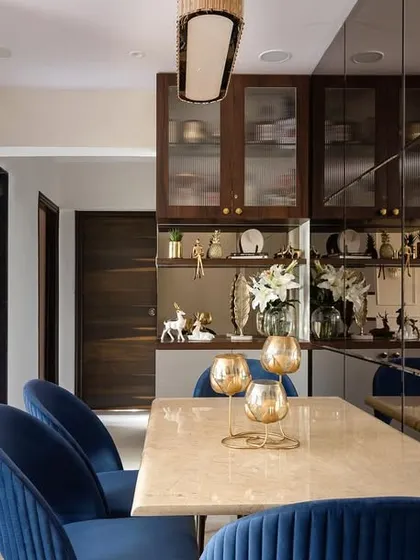 The completed dining space from 'The Adobe' project next to its 3D render. The custom marble table, blue chairs, and mirror wall were executed exactly as planned.