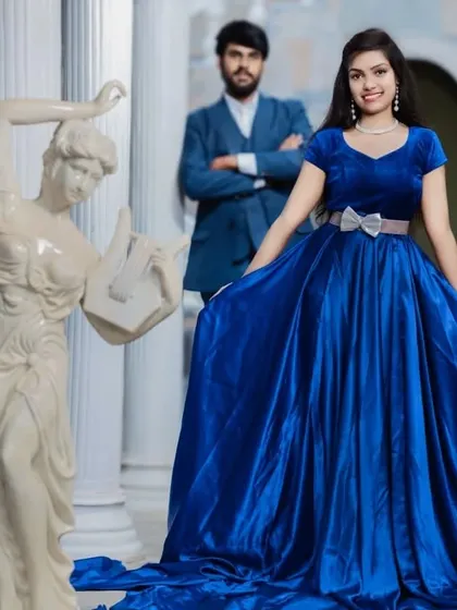 Posed with classical statues, the couple looks timeless. The rich satin of the blue gown adds a touch of luxury to their pre-wedding photos.