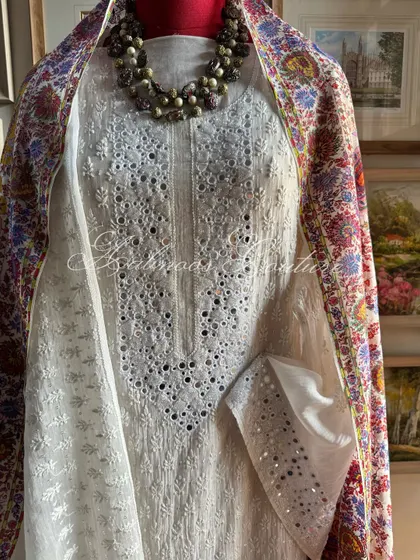 This view highlights the intricate hand-embroidery and mirrorwork on the yoke and sleeve of the Chikankari suit, demonstrating the level of detail in our craftsmanship.