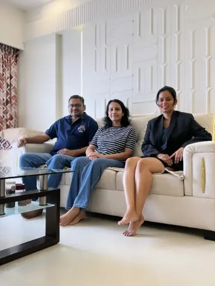 A candid photo with my clients, enjoying the comfortable and stylish living room we designed for their family.