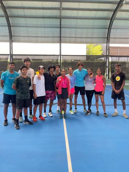 The team gathers to celebrate Sanmitha's success. This group photo shows the supportive environment that helps our young players thrive.