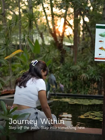 A journey within. A guest takes a quiet moment by a pond, stepping off the path to find something new.