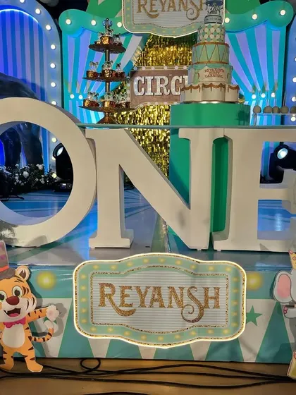 The "ONE" marquee letters in front of the pastel circus stage, with custom signs and character cutouts.