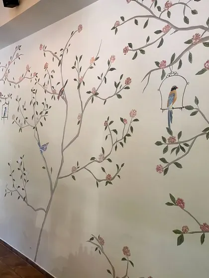 The completed floral mural at Cafe Wink, spanning the length of the wall and adding a touch of timeless elegance with its birds and blossoms.