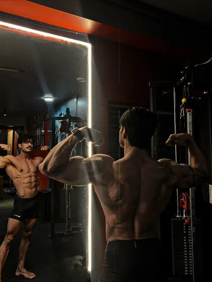 Look in the mirror, that's your biggest competitor. A classic bodybuilding pose showing both front and back aesthetics in the reflection.