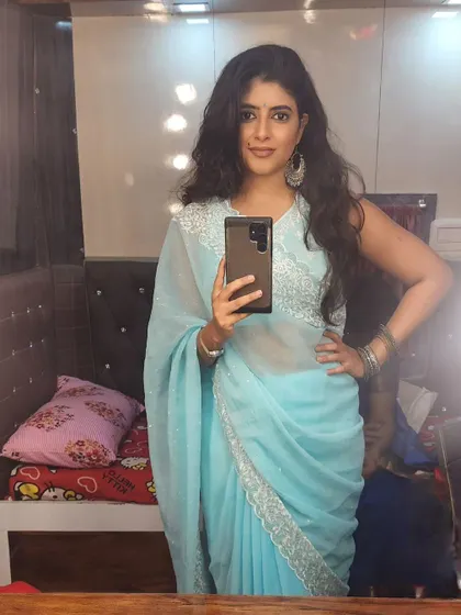 A mirror selfie in a light blue saree, a simple and elegant look for a smaller gathering.