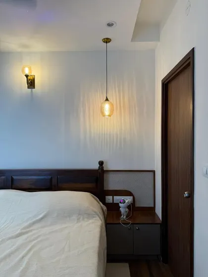 Pendant lights on, stress off. This bedroom’s got that “I meditate but also binge K-dramas” kind of vibe, with warm wood and soft, layered lighting.