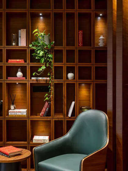 We love creating small, thoughtful moments within a larger space. This reading nook with its custom wooden bookshelf and comfortable armchair provides a quiet corner for reflection in a busy corporate environment.