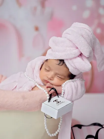 A close-up of our little princess holding a miniature designer bag while she sleeps. The details make this shot so charming and unique.