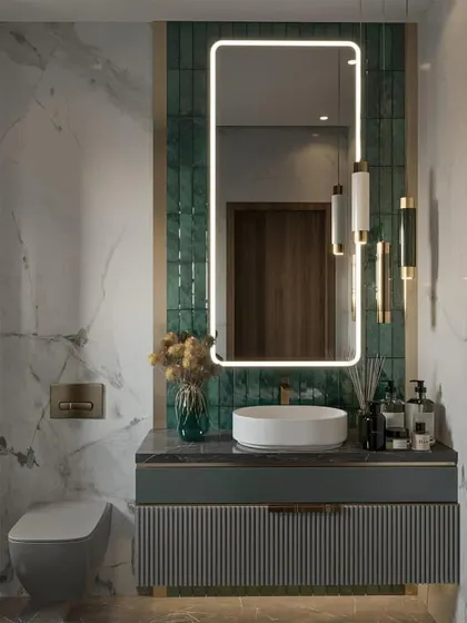 This bathroom design is so elegant. The emerald green tiled accent wall provides a rich pop of color against the white marble, and the gold fixtures add a touch of glamour.
