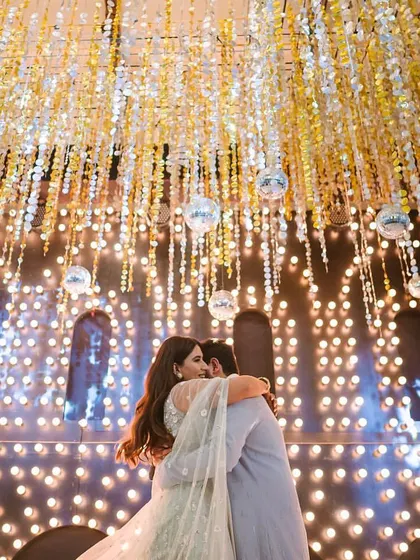 A beautifully framed shot of a couple's embrace under a stunning canopy of lights. I help choreograph moments like these that are not only emotional but also create incredible photo opportunities.