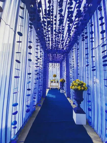 The stunning entrance tunnel, draped in blue fabric with hanging details, creating a dramatic and memorable entry for guests.