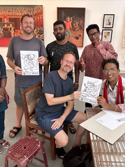 Two international visitors proudly hold up their completed signature art pieces at my exhibition in Colombo.