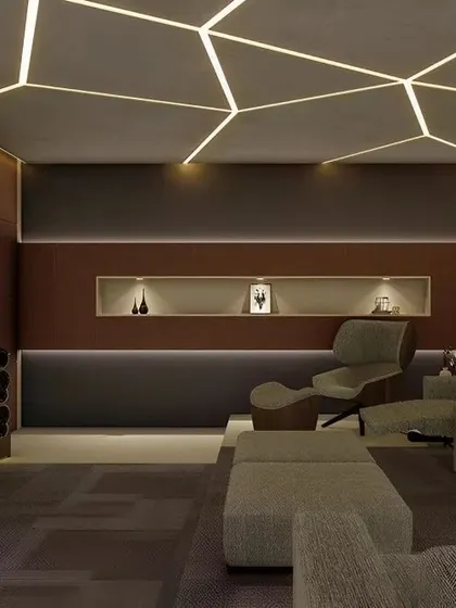 This home theater boasts a unique geometric lighting pattern on the ceiling. The comfortable lounge chairs and dark color scheme are designed for maximum viewing comfort.