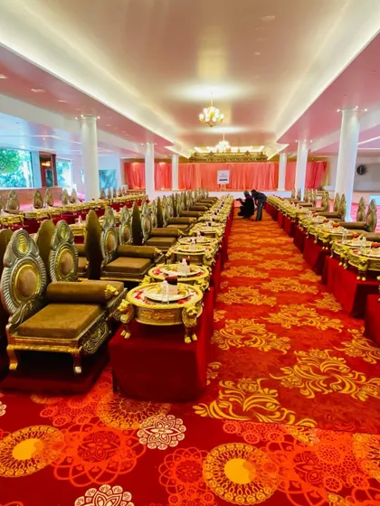 A panoramic view of the magnificent hall set up for a Royal Rajasthani Thali meal. The long rows of ornate seating create a visually stunning and grand dining scene.