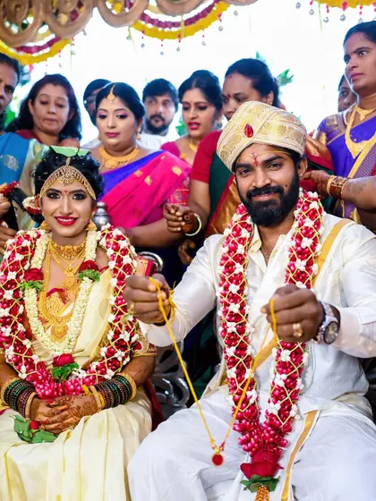 A beautiful portrait of a couple during their traditional wedding ceremony, surrounded by family. We aim to capture the cultural richness and personal joy of such significant events.