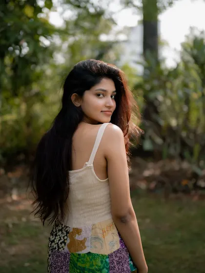 A beautiful over-the-shoulder shot of actress Rachana Inder in a park. The sunlight catches her hair, creating a lovely halo effect in this natural portrait.