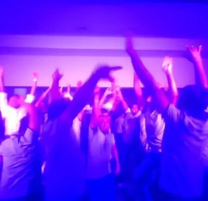 The employees with their hands up, fully engaged in the party.