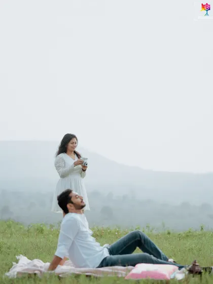 A relaxed and natural portrait from a picnic, where the groom-to-be is lying back while his partner takes a photo.