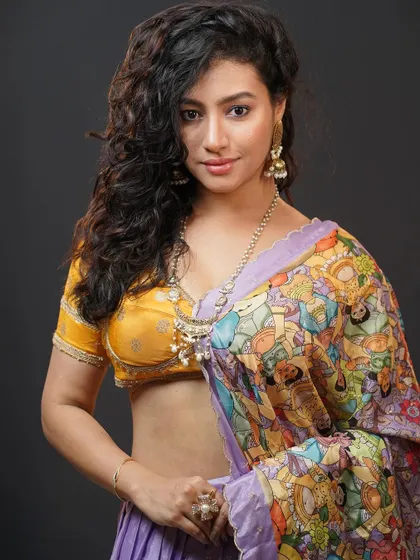 A classic portrait pose that highlights the beautiful jewelry and the model's curly hair.