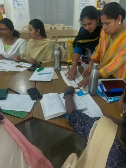 A close-up of teachers working with number strips and other materials. The focus is on understanding the 'why' behind math, not just memorizing procedures.