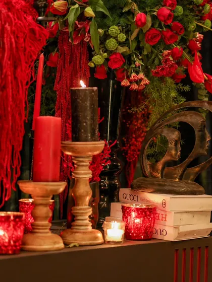 A curated corner featuring modern art, classic books, and bold candles. These details contribute to a layered and personalized event aesthetic.
