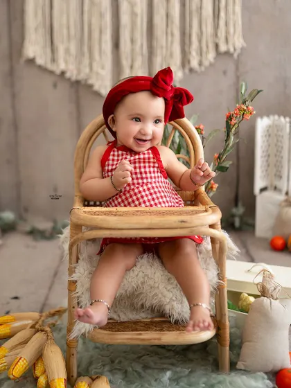 A big, happy smile from the little chef, sitting in his high chair.