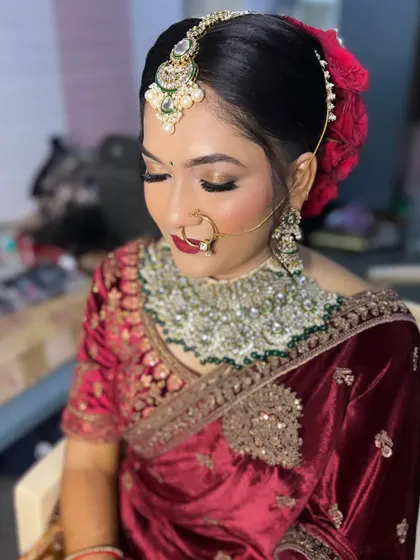 A close-up of Sheethal's North Indian reception look. We did a golden glittery eye and a classic red lip to go with her maroon velvet saree.