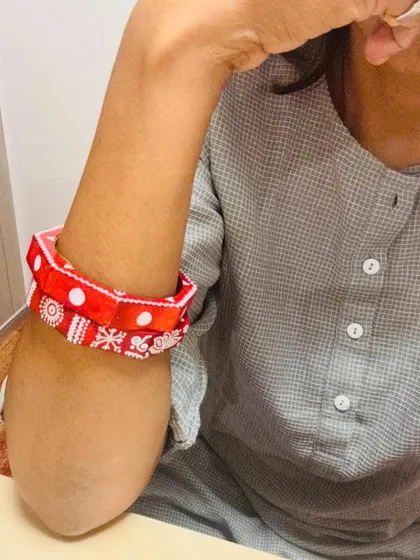 Another look at the Maati bangles, showing how they can be pushed up the arm for a different style. The hand-painted white details pop against the red base.