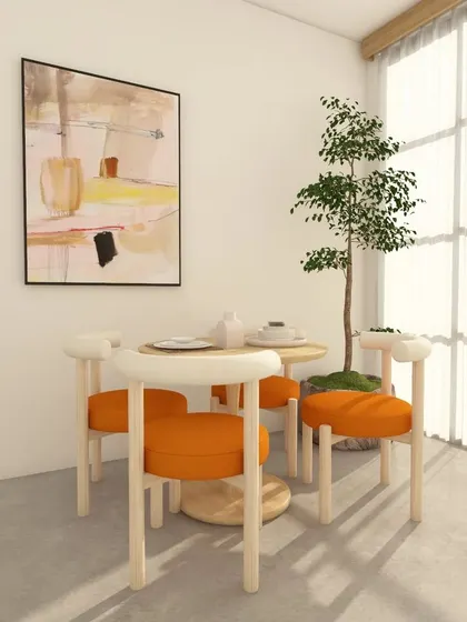 Natural light floods this minimalist dining area, highlighting the clean lines of the furniture and the simple, elegant setup.