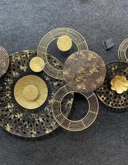 A beautiful metal wall art piece. This decorative item, with its circular and floral motifs in black and gold, can serve as a stunning focal point in a living room or hallway.