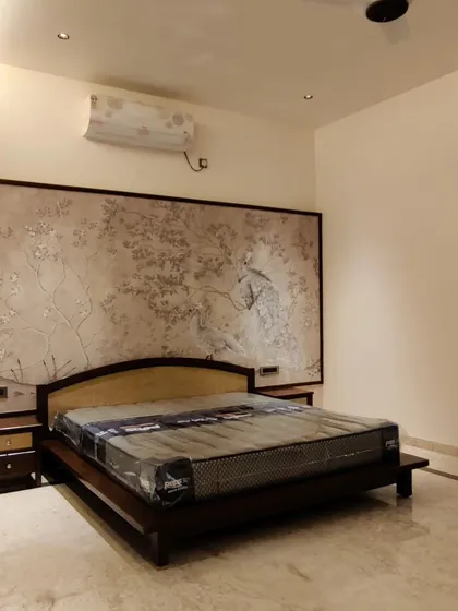 This bedroom features a large, custom-made textured art panel behind the bed. This type of decorative paneling can be adapted for home theatres to hide acoustic treatments and speakers.