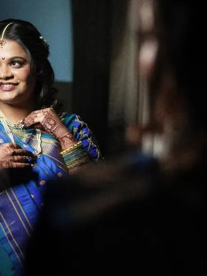 The bride looking at her reflection, a smile on her face. A beautiful, intimate moment captured before the ceremony.