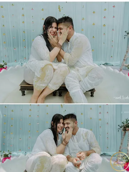 A cute moment where the couple playfully applies Haldi to each other's faces.
